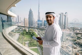 Homme d'affaires émirati confiant sur un balcon de Dubai