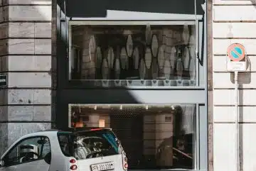 white 5 door hatchback parked beside brown brick building during daytime